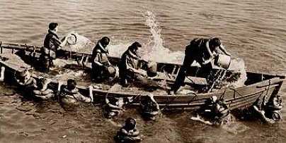People bailing water out of a boat